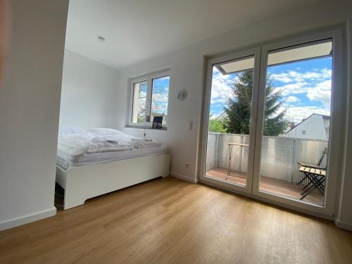 a bedroom with a bed and a large sliding glass door at LUX Apartments in Mörfelden-Walldorf