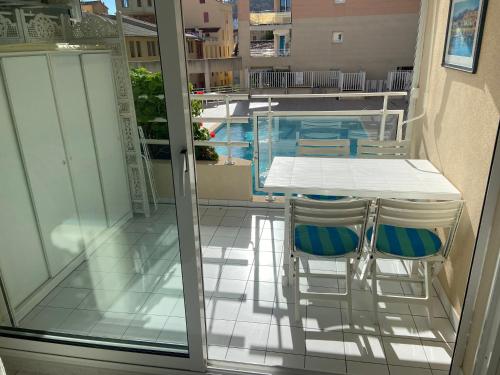 - un balcon avec une table et des chaises à côté de la piscine dans l'établissement 2 pièces bord de mer, à Vallauris
