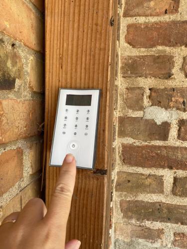 a person holding a remote control on a brick wall at Strand Familien Doppelhaushälfte ,,INGER'' #Familien-Treffen in Rappin