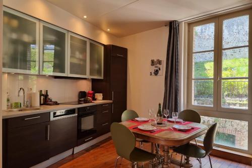 a kitchen with a table and chairs in a kitchen at La Maison du Puits with wood-burning stove Honfleur center 5P in Honfleur