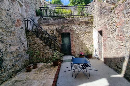 a table and chairs in an alley with a door at La Maison du Puits with wood-burning stove Honfleur center 5P in Honfleur