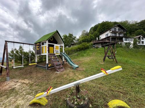 einen Spielplatz mit kleinem Haus und Schaukel in der Unterkunft Karadzhovata Kashta in Slatograd