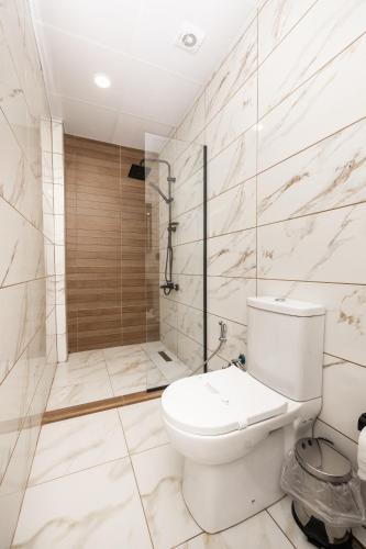 a white bathroom with a toilet and a shower at Perla Blanca Hotel in Trabzon