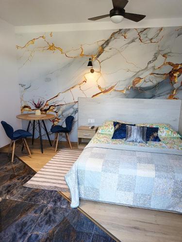 a bedroom with a bed with a tree mural on the wall at City Center Apartments - Apartamenty nad rzeką Nettą - Kilińskiego 22 in Augustów