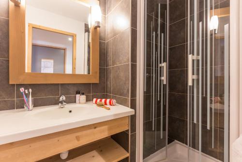 a bathroom with a sink and a shower at Résidence Pierre & Vacances Aconit in Les Menuires