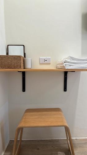 a wooden shelf with a wooden stool on a wall at 山有巷宅 Alley House in Puli