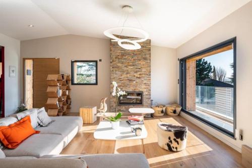 un salon avec un canapé et une cheminée dans l'établissement Les Muriers - Stunning wooden modern house, à Saint-Didier-au-Mont-dʼOr