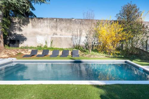 - une piscine avec des chaises longues dans la cour dans l'établissement Les Muriers - Stunning wooden modern house, à Saint-Didier-au-Mont-dʼOr
