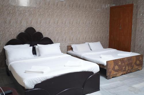 2 Betten nebeneinander in einem Zimmer in der Unterkunft Le Radha Grand in Mahabalipuram