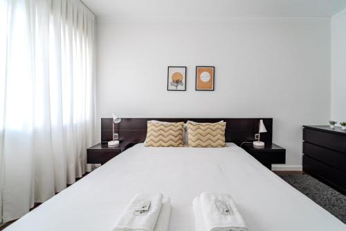 a bedroom with a large white bed with two night stands at Norton Matos - T2 in the heart of Braga by House and People in Braga