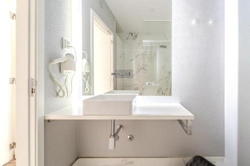 a white bathroom with a sink and a mirror at Norton Matos - T2 in the heart of Braga by House and People in Braga