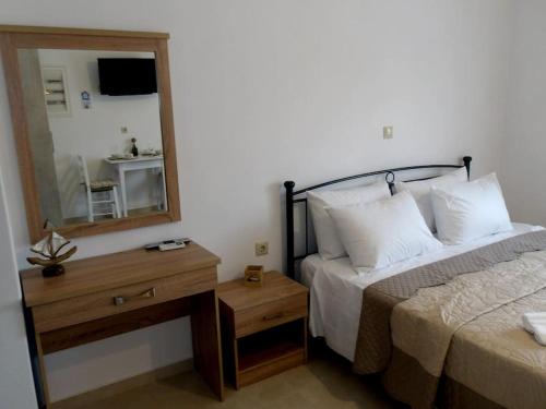 a bedroom with a bed and a mirror and a table at Lady S Holiday Studio in Lampi