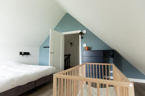 1 dormitorio con cama y escalera en Vakantiehuis met omheinde tuin, en Dokkum
