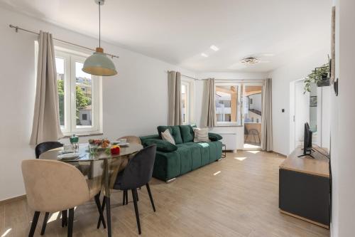 ein Wohnzimmer mit einer grünen Couch und einem Tisch in der Unterkunft Beachfront Apartment Betty - Happy Rentals in Vrbnik