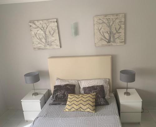 a bedroom with a bed with two night stands and two lamps at Frente á Praia in Portimão