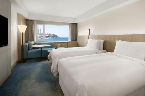 um quarto de hotel com duas camas e uma janela em The Westin Josun Busan em Busan