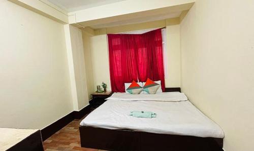 FabHotel Palbhu في جانجتوك: غرفة نوم مع سرير مع نافذة حمراء