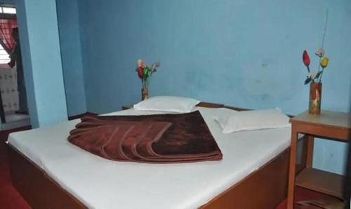 Una cama con una manta encima. en FabHotel Palbhu, en Gangtok