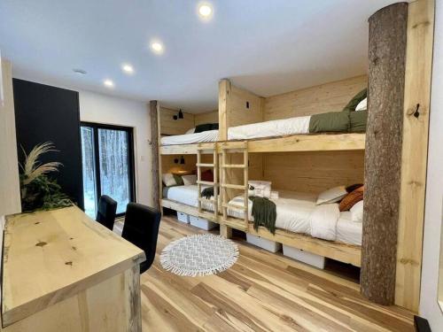 プティット・リヴィエール・サン・フランソワにあるONИEA l Sauna & Spaの二段ベッド2台、デスクが備わる客室です。