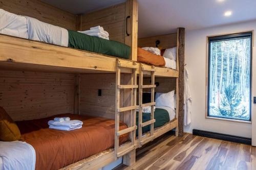 a bedroom with bunk beds in a log cabin at ONNEA - Magical Chalet with Stunning Views, Sauna & Hot Tub in Petite-Rivière-Saint-François