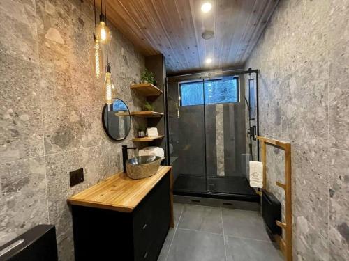 a bathroom with a shower with a wooden counter and a sink at ONNEA - Magical Chalet with Stunning Views, Sauna & Hot Tub in Petite-Rivière-Saint-François