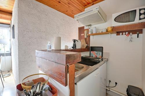 Il comprend une petite cuisine équipée d'une cuisinière et d'un évier. dans l'établissement Red Eden - Joli studio proche jardin roseraie, à LʼHay-les-Roses