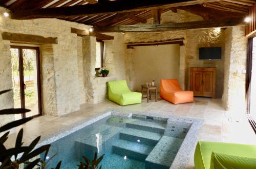 einen Pool in der Mitte einer Terrasse mit zwei Stühlen in der Unterkunft les gîtes de fred en Dordogne, Maisons avec piscines privées et chauffées in Florimont-Gaumiers