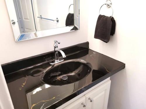 baño con lavabo negro y espejo en Old Quebec - Les Suites Montcalm #2 - Free Parking, en Quebec