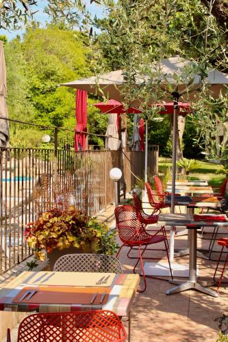 a patio with tables and chairs and an umbrella at La Lune De Mougins - Hotel & Spa in Mougins