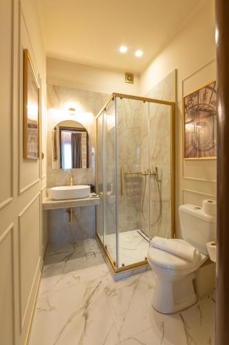 a bathroom with a shower and a toilet and a sink at L Suites The Writer's House in Gythio