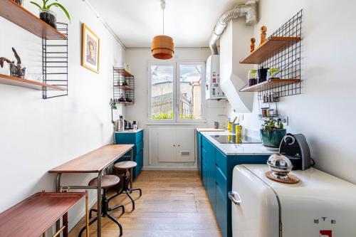 une petite cuisine avec des placards bleus et une table dans l'établissement GuestReady - A Zen haven near Montmartre, à Paris