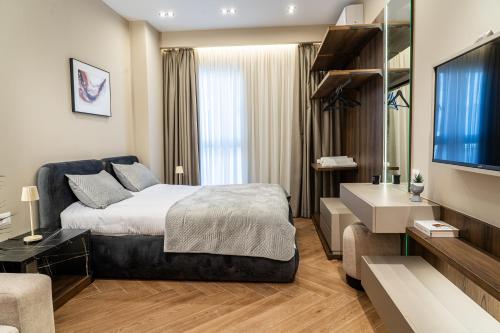 a bedroom with a bed and a sink and a television at ProGarden Luxury Apartments Tirana in Tirana