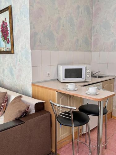 a kitchen with a table and a microwave on a counter at Hotel Vesta in Brovary