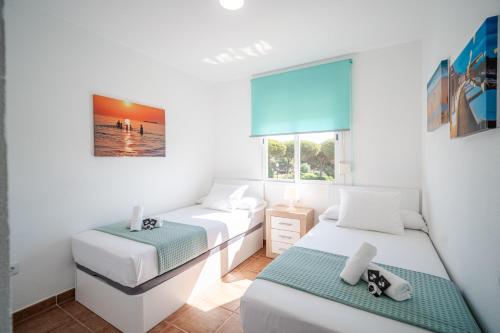 a bedroom with two beds and a window at Precioso Apartamento Jardin del Golf 1, Novo Sancti Petri in Chiclana de la Frontera