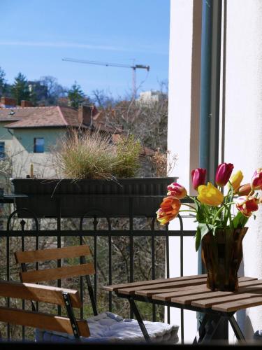 a table with a vase of flowers on a balcony at Choco Home & Hostel in Cluj-Napoca