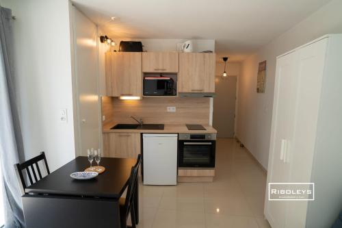 - une petite cuisine avec une table et un comptoir dans l'établissement Vias-Plage - Superbe T1 à 100m de la plage, à Vias