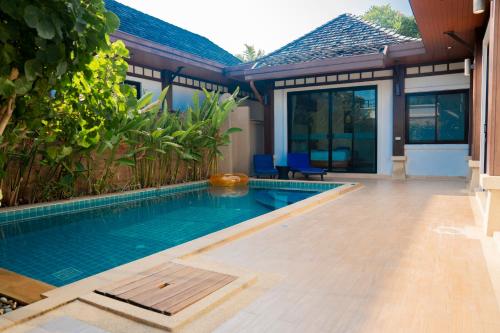 a swimming pool in front of a house at Near beach 3bedroom pool villa.（Rawai VIP B6） in Rawai Beach