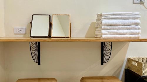 a shelf with two mirrors and towels on it at 山有巷宅 Alley house in Puli