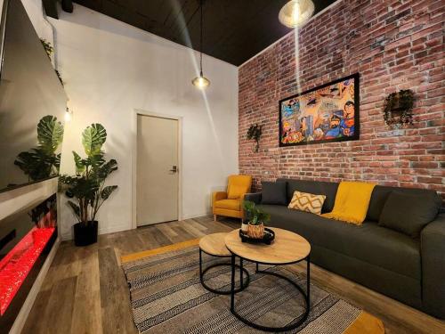 a living room with a couch and a brick wall at Loft Style Industriel Centre ville Parking Gratuit in Quebec City