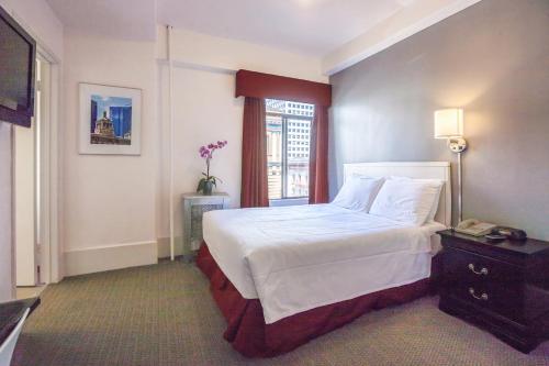 Un pat sau paturi într-o cameră la Grant Plaza Hotel