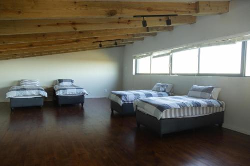 a room with three beds and two windows at Askop Hilltop Farm House The Crags Plettenberg Bay in The Crags