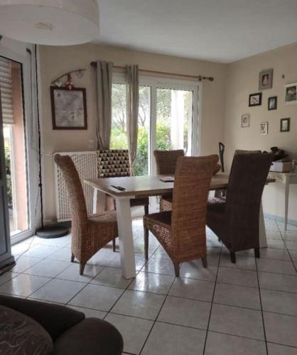 une salle à manger avec une table et des chaises dans l'établissement Villa au calme avec piscine, à Villardonnel