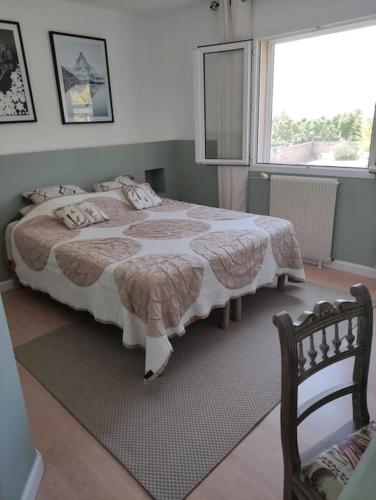 une chambre avec un grand lit et une fenêtre dans l'établissement Villa au calme avec piscine, à Villardonnel