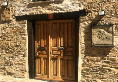 eine Holztür an der Seite eines Steingebäudes in der Unterkunft Hotel Rural El Rincón de Marta in Yanguas