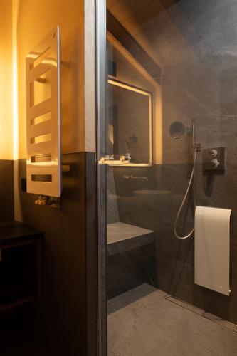 a bathroom with a shower and a sink and a toilet at Camino Rustic Chic Hotel in Livigno