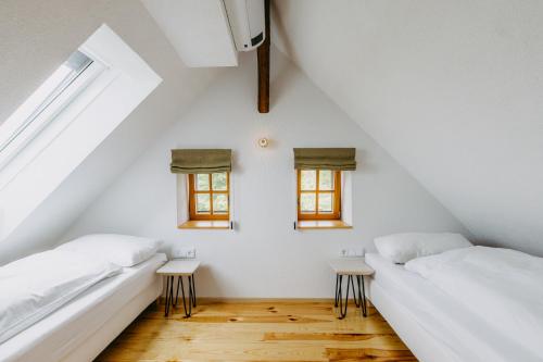 2 Betten in einem Zimmer mit 2 Fenstern in der Unterkunft Urlaub im Kellerstöckl Dunst in Strem