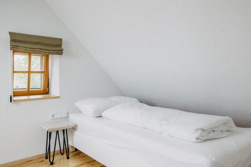 a bed with white sheets and a window in a room at Urlaub im Kellerstöckl Dunst in Strem