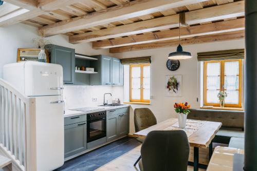 eine Küche mit blauen Schränken und einem Tisch mit einem Esszimmer in der Unterkunft Urlaub im Kellerstöckl Dunst in Strem