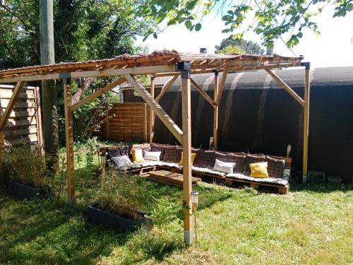 a wooden pergola with couches in a yard at Le Cosy Cabarieu in Saint-André-de-Cubzac