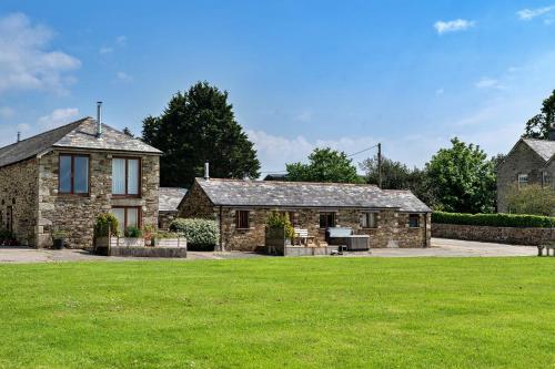 a stone house with a lawn in front of it at Finest Retreats - The Shippon at Lestitha in Liskeard